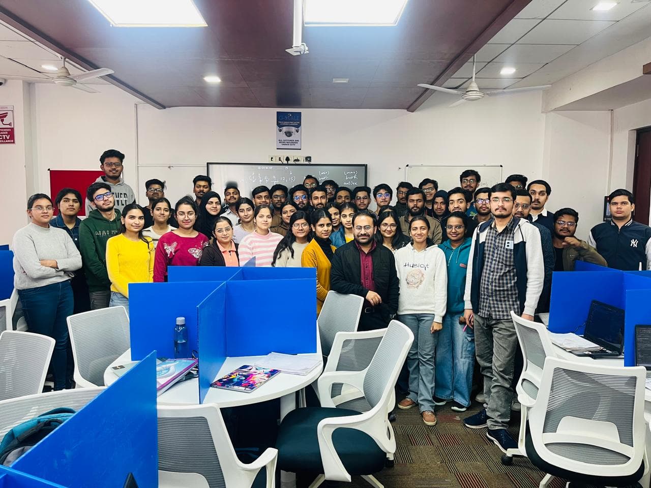 Students and their mentor standing together in a classroom